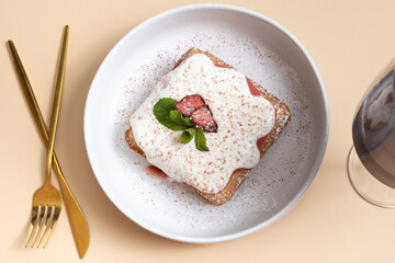 Belgian waffles with strawberry confit and cream sauce on beige background top view.