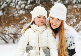 Young blond mother with her little daughter outdoors