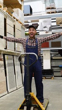 Funny warehouse worker rides on forklift loader in store. Vertical video
