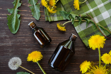 Bottles of essential oil with flowers dandelions. Healing herbs. Dandelions tinctures. Fragrant...