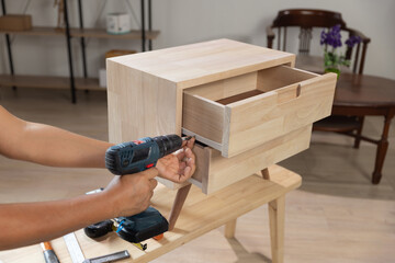 Handyman fixing over tight drawer slides rail of bedside table. - 786217529
