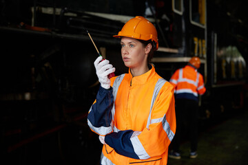 worker using walkie talkie and talking about work at construction train station