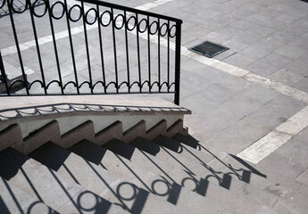 Wrought iron on the metal stair railing and its shadow.