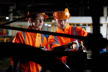 engineers or technicians working and checking construction inside under a train