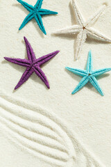 Colored starfish on white fine sand. - 786219515