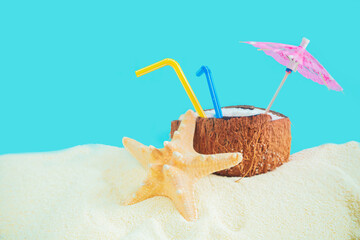Coconut with a straw, shells, starfish and a sun umbrella on the sand. - 786219708
