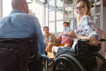 Fototapeta na wymiar Social inclusion at a cafe: Person in wheelchair enjoying coffee with friends