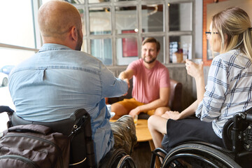 Friends sharing a moment at a cafe with person in a wheelchair demonstrating inclusion
