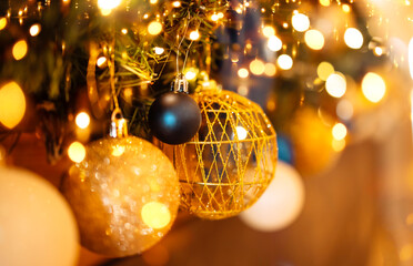 Close-up of gold and silver balls on the Christmas tree. Beautiful bokeh effect with lights