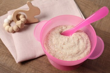 Baby food. Puree in bowl and toy on wooden table