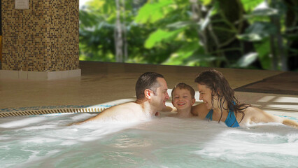 Happy family enjoy relaxation in the hot tub pool at the spa