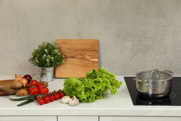 Cooking dinner. Pot and fresh vegetables on countertop in kitchen