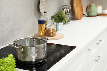 Cooking dinner. Pot on cooktop in kitchen