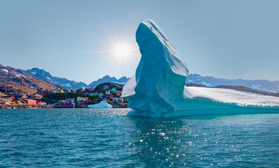 Melting icebergs by the coast of Greenland, on a beautiful summer day - Picturesque village on...