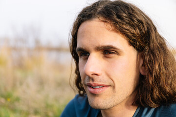 Horizontal photo close-up of a thoughtful man by the river. Lifestyle concept.