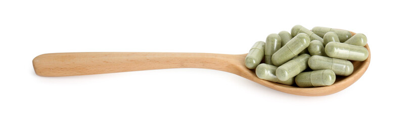 Vitamin capsules in wooden spoon isolated on white. Health supplement