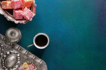 Traditional Turkish coffee and Turkish delight on a painted dark blue-green wooden background - 786225358