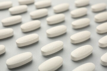 Obraz na płótnie Canvas Vitamin pills on light grey background, closeup. Health supplement