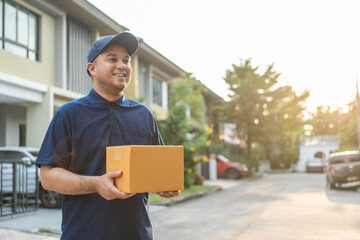 Blue Delivery asian man holding parcel cardboard box. Male employee in cap t-shirt working as...