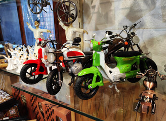 Miniature multicolored vintage motorcycle models in the shop window