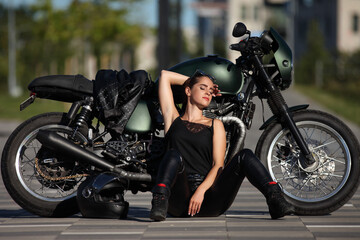 Obraz na płótnie Canvas Portrait of young woman on a black motorcycle