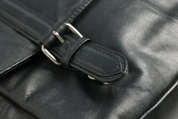 Black natural leather with buckle as background, closeup