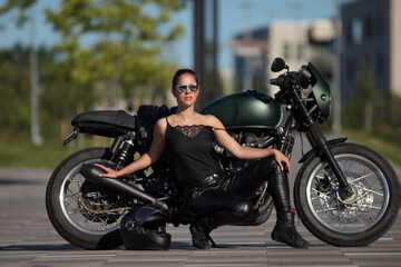 Portrait of young woman on a black motorcycle