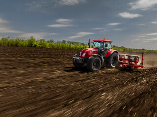 Fototapeta premium aerial view of a moving red tractor with seeder in ploughed field with motion blur