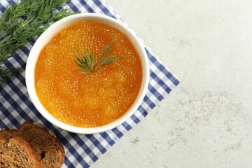 Fresh pike caviar in bowl, dill and bread on light grey table, top view. Space for text