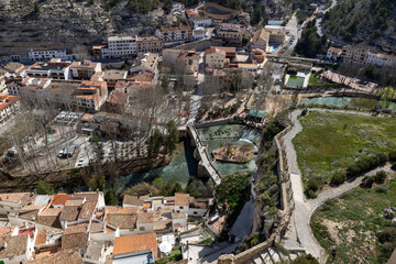 Panoramic view of the town of Alcalá del Júcar. Its popular Roman bridge, cave houses, river beach, castle and Church of San Andrés in the gorge of the júcar rive, Albacete, Spain.