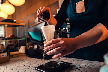 Barista preparing filter coffee in a modern coffee shop.