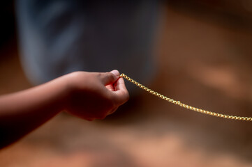 close up of a hand holding a necklace