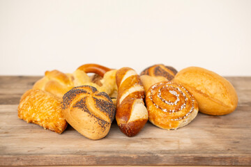 wicker basket overflowing with freshly baked pastries: cheese and poppy seed buns, pretzels, and...