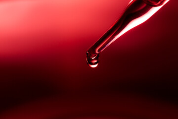Macro science experiment, water drops, liquid dripping from glass pipette in red laboratory 