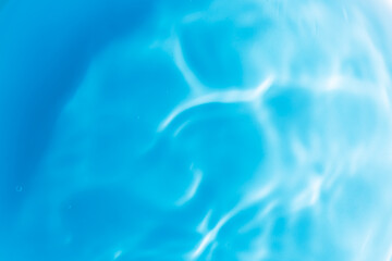 Fototapeta na wymiar blue water surface,Transparent blue clear water surface texture with ripples, splashes and bubbles. Abstract summer banner background Water waves in sunlight with copy space Cosmetic moisturizer micel