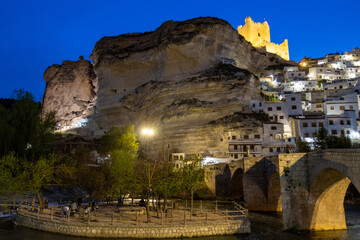 Alcal&aacute; del J&uacute;car at night, located on a rock formed by the gorge of the J&uacute;car River, cave houses roman bridge, castle, Church of San Andr&eacute;s Ap&oacute;stol (Albacete, Spain).