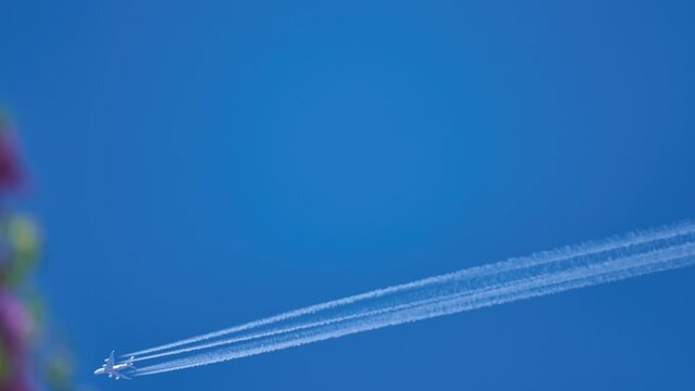 Large passenger plane flies over blue sky