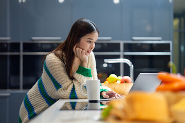Happy woman relaxing at home - young Asian woman Relaxed working with computer at home. remote working from home office during quarantine