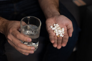 Taking many different pills man's hand glass water. Selective focus, taking vitamins, pill...