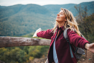 Woman contemplating a beautiful landscape. Young woman breathing pure air in a forest. Young woman hiking and going camping in nature. Person with backpack walking in the forest - 786265309