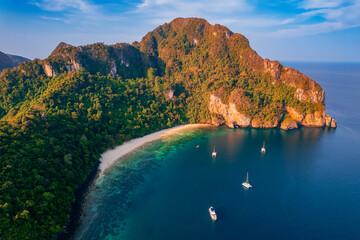 Concept trip Tourist boat in Thai travel. Aerial view landscape with sunrise on Phi Phi with white...