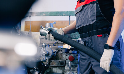 Industrial worker with hydraulic hoses with fitting connection pipe background cnc press