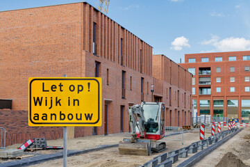 Sign with the Dutch text for "Attention - Residential area under construction" in front of new family homes in Lent Nijmegen,  The Netherlands