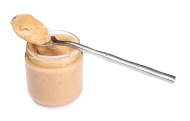 Tasty nut paste in jar and spoon isolated on white