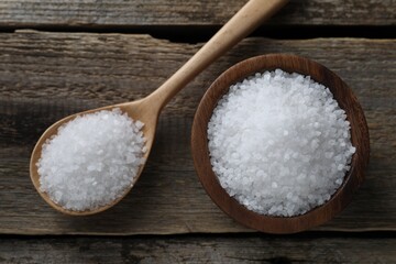 Fototapeta na wymiar Organic salt in bowl and spoon on wooden table, flat lay