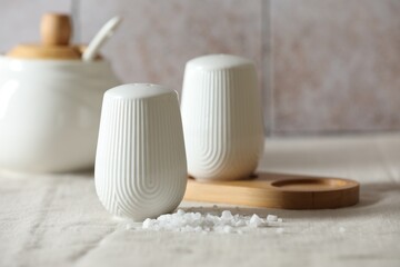 Organic salt and shaker on table, closeup. Space for text
