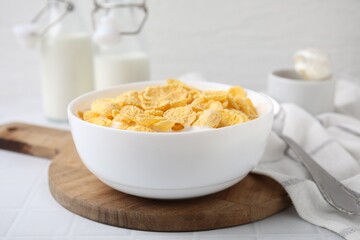Breakfast cereal. Tasty corn flakes with milk in bowl on white table