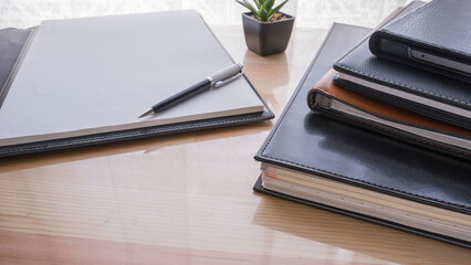 office table with notepad, pen, notebooks and folder