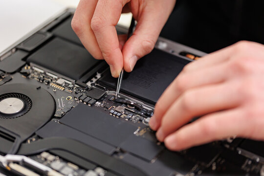 RUSSIA - March 23, 2024: Repair Macbook pro Apple, maintenance and replacement of thermal paste, broken screen and replace used rechargeable batteries for recycling