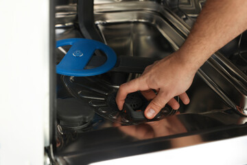 Serviceman repairing and examining chrome dishwasher, closeup